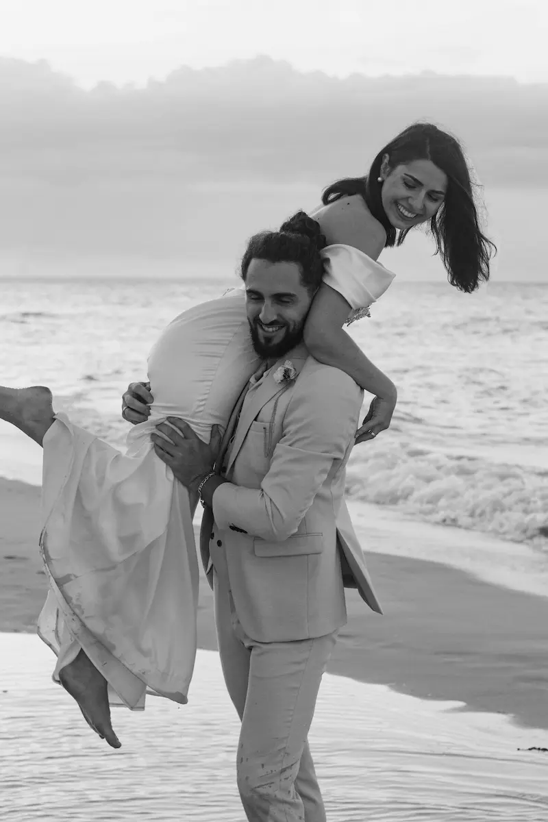 recién casados riendo en la playa