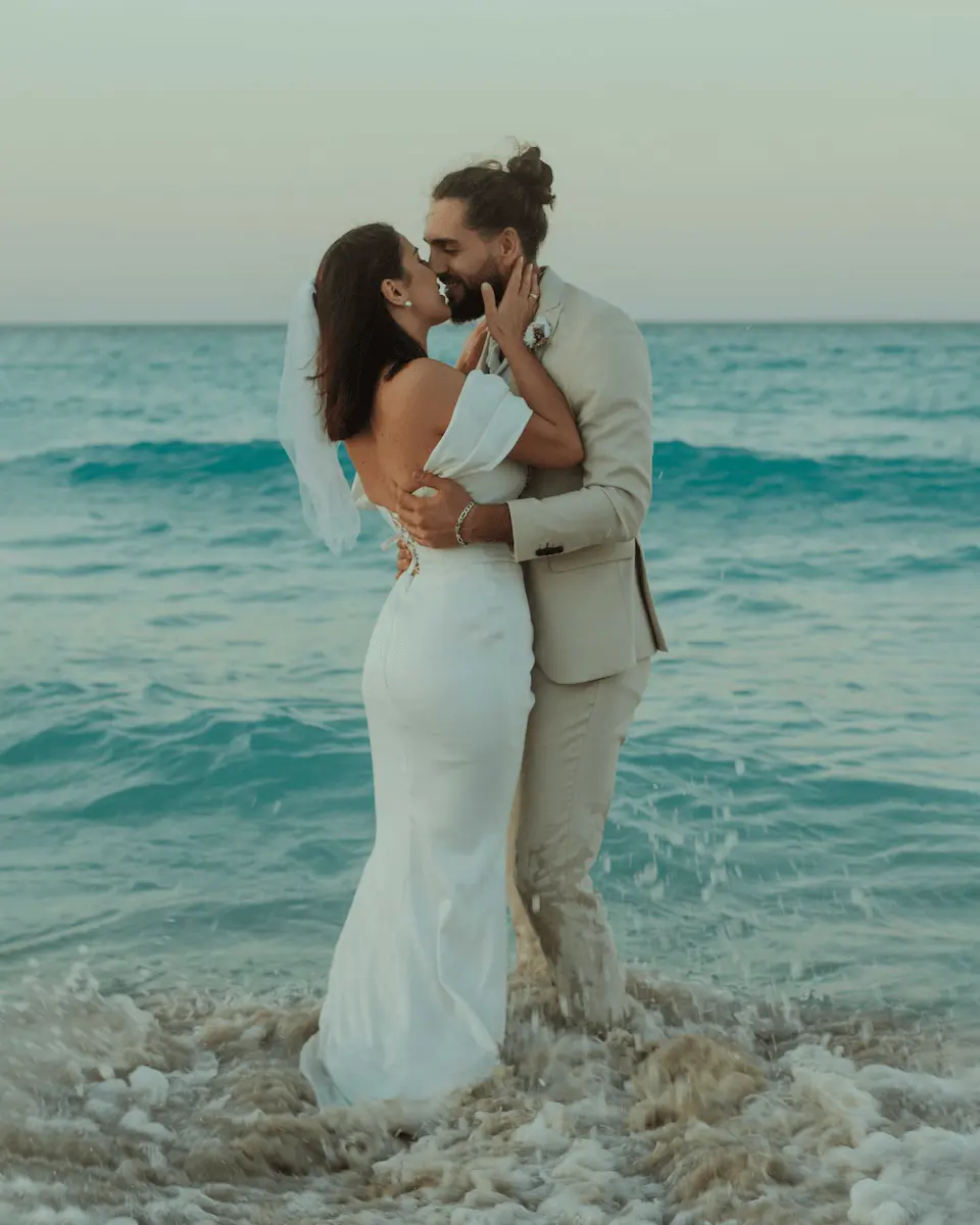 pareja de novios besandose en la orilla de la playa