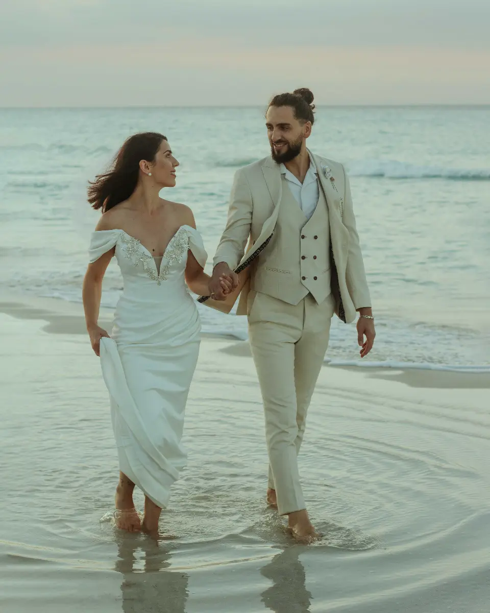 pareja caminando feliz por la playa